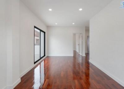 Spacious living room with hardwood flooring and large window