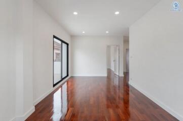 Spacious living room with hardwood flooring and large window