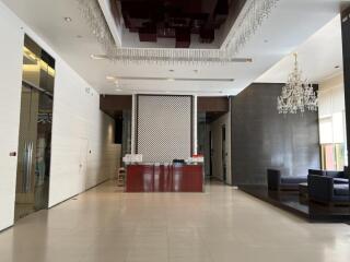 Lobby with a reception desk, seating area, and chandelier