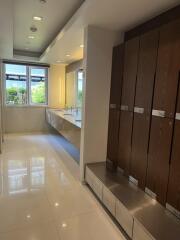 Spacious modern bathroom with lockers, double sink, and large mirror