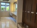 Spacious modern bathroom with lockers, double sink, and large mirror