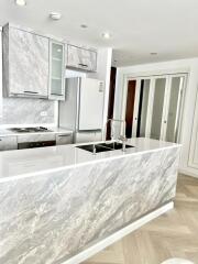 Modern kitchen with marble island and stainless steel appliances