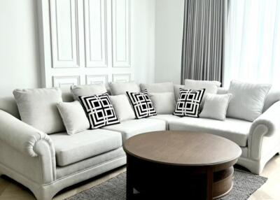 Bright living room with a light grey sofa and a round wooden coffee table