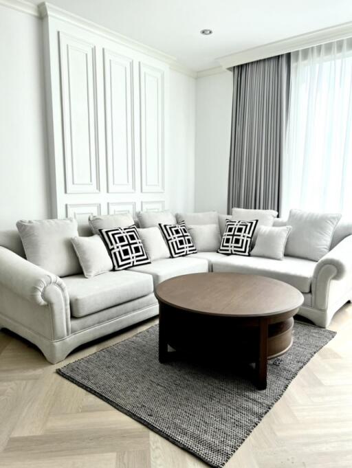 Bright living room with a light grey sofa and a round wooden coffee table