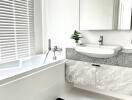 Modern bathroom with a bathtub, sink, and a large mirror