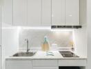 Modern white kitchen with sink, stove, and backsplash