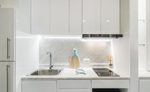 Modern white kitchen with sink, stove, and backsplash