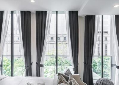 Bright bedroom with large windows and curtains