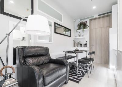 Modern living area with black leather armchair and dining table