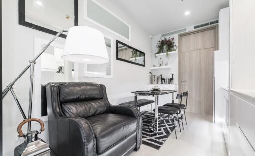 Modern living area with black leather armchair and dining table