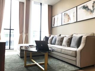 Modern living room with natural light, plush sofa, and decor