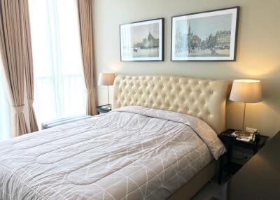 Bedroom with bed, two lamps, and framed art