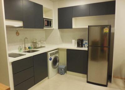 Modern kitchen with dark cabinetry and white countertops