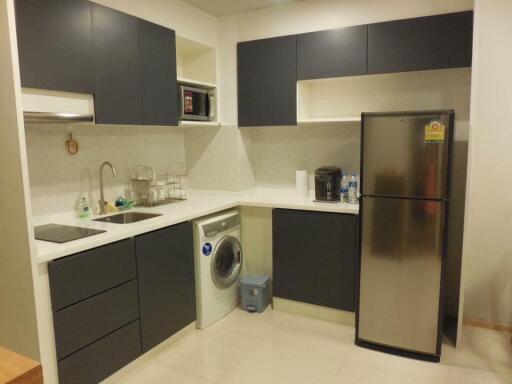 Modern kitchen with dark cabinetry and white countertops