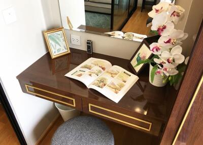 Bedroom vanity with mirror, flowers, and open book