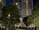 Front view of a residential building at night with greenery