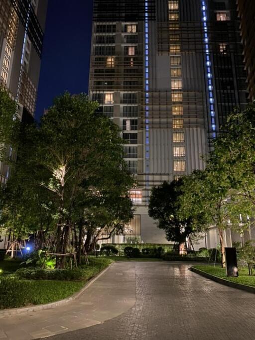 Front view of a residential building at night with greenery