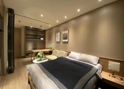 Well-lit modern bedroom with bed, sofa, and wall art