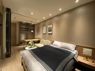 Well-lit modern bedroom with bed, sofa, and wall art