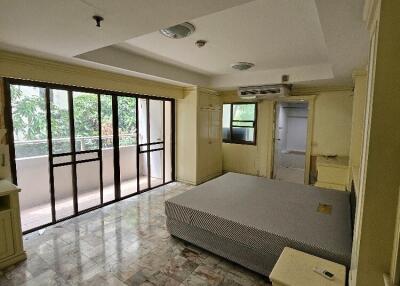 Spacious bedroom with large windows and balcony access