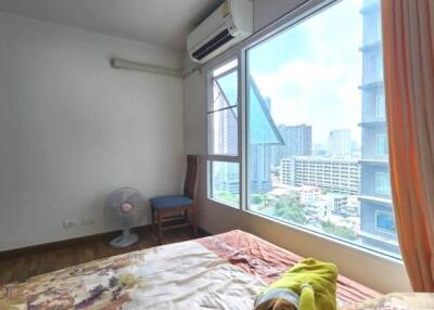 Spacious bedroom with a window view of city buildings