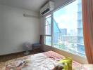 Spacious bedroom with a window view of city buildings