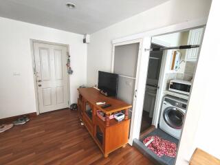 Living room with wooden furniture and access to kitchen area