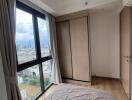 Bedroom with city view and wooden wardrobe