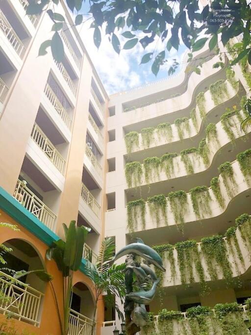 Exterior view of a multi-story building with balconies and greenery