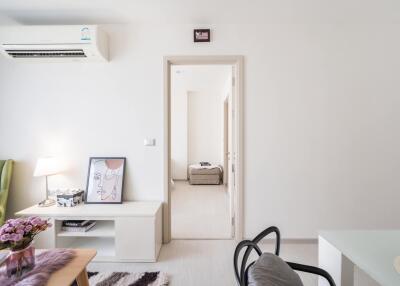 Modern living room with minimalist decor and adjacent hallway