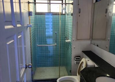 Modern bathroom with glass shower door and blue tile walls