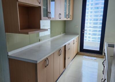 Long kitchen with wooden cabinets and glass-front cupboards