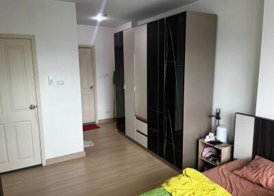 Modern bedroom with bed, wardrobe, and wooden floor