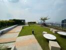 A spacious rooftop garden with greenery and city views