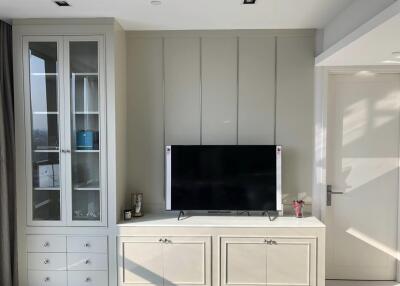 Living area with mounted TV and storage cabinets