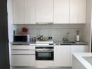 Modern kitchen with white cabinets and stainless steel appliances