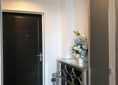 Hallway with decorative mirror cabinet and floral arrangement