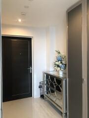 Hallway with decorative mirror cabinet and floral arrangement