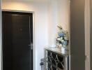 Hallway with decorative mirror cabinet and floral arrangement