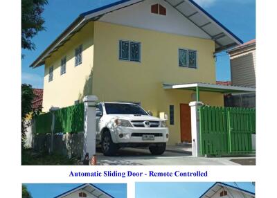 Front view of a villa with a green gate and covered parking space