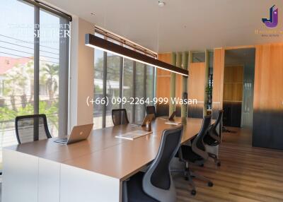 Modern office space with long conference table and laptops