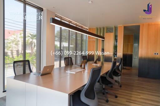 Modern office space with long conference table and laptops