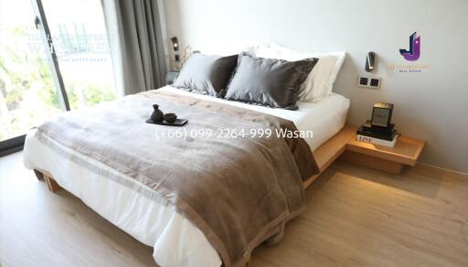 Modern bedroom with a large bed, wooden nightstands, and decorative pillows