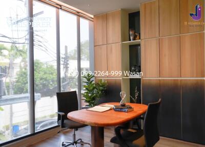 Modern home office with large windows and wooden furniture