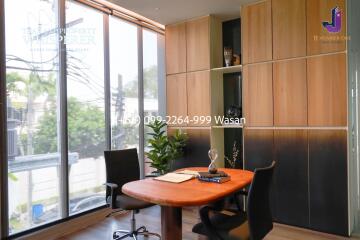 Modern home office with large windows and wooden furniture