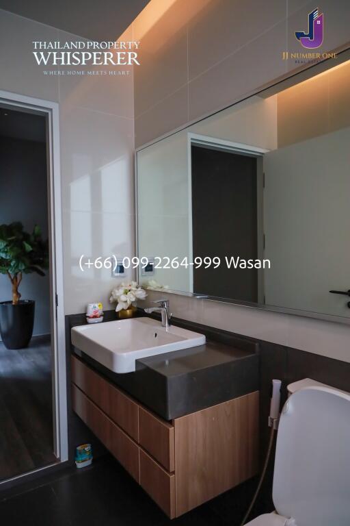 Modern bathroom with large mirror and wooden cabinetry