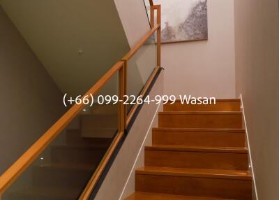 Staircase with wooden steps and glass railing in a modern interior