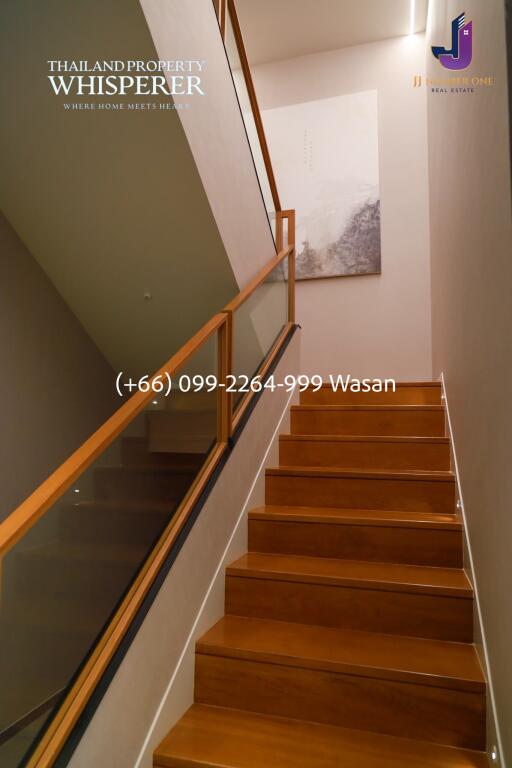 Staircase with wooden steps and glass railing in a modern interior