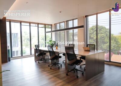 Modern office space with large windows, conference table, and ergonomic chairs