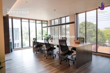 Modern office space with large windows, conference table, and ergonomic chairs